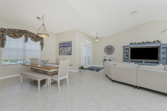 tiled dining room featuring ceiling fan, french doors, and vaulted ceiling