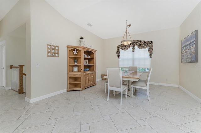 tiled dining space featuring lofted ceiling