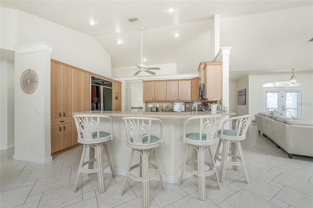 kitchen with light brown cabinets, lofted ceiling, french doors, ceiling fan, and kitchen peninsula