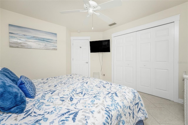 bedroom with ceiling fan, light tile patterned floors, and a closet