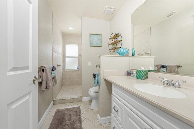 bathroom with tile patterned floors, vanity, toilet, and tiled shower