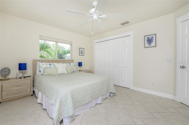 bedroom featuring ceiling fan, light tile patterned floors, and a closet