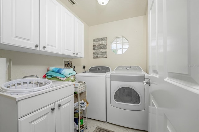 laundry area featuring cabinets, light tile patterned floors, and separate washer and dryer