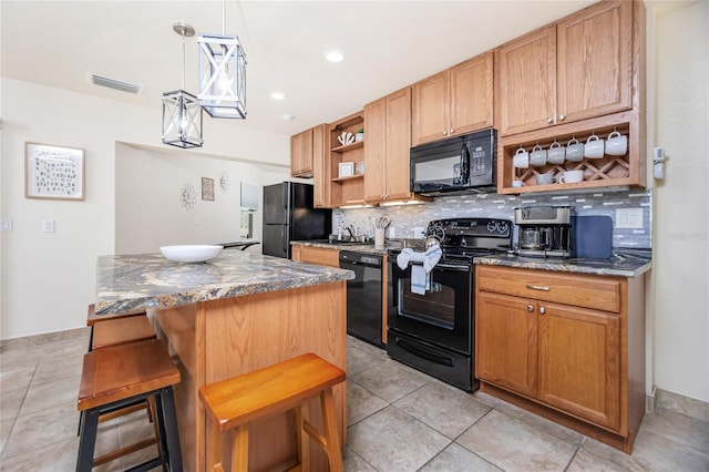 kitchen with backsplash, black appliances, a kitchen breakfast bar, decorative light fixtures, and a kitchen island