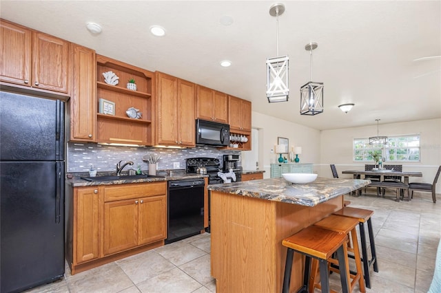 kitchen with a center island, pendant lighting, a breakfast bar area, decorative backsplash, and black appliances