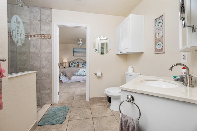 bathroom with tile patterned floors, vanity, ceiling fan, tiled shower, and toilet