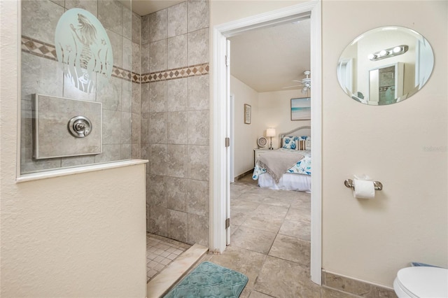 bathroom with tile patterned floors, ceiling fan, toilet, and tiled shower