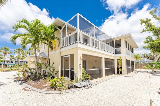 back of house with a sunroom and a balcony