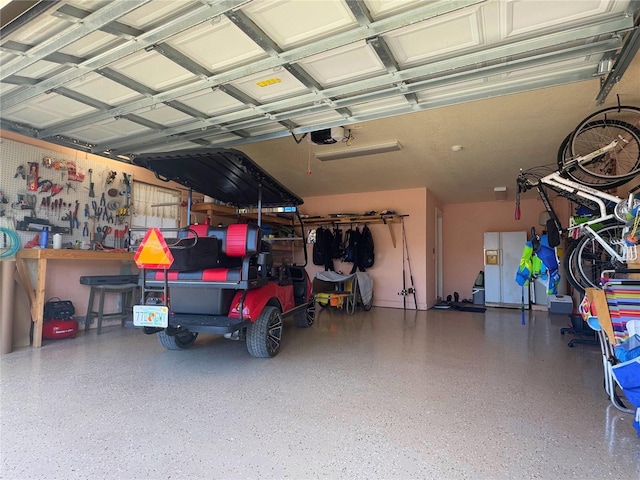 garage with a workshop area and a garage door opener