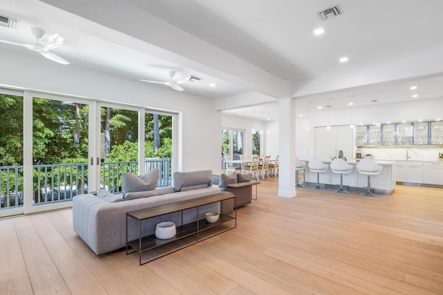 living room featuring ceiling fan and light hardwood / wood-style flooring