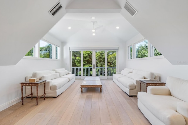 living room with light wood-type flooring, high vaulted ceiling, and a wealth of natural light