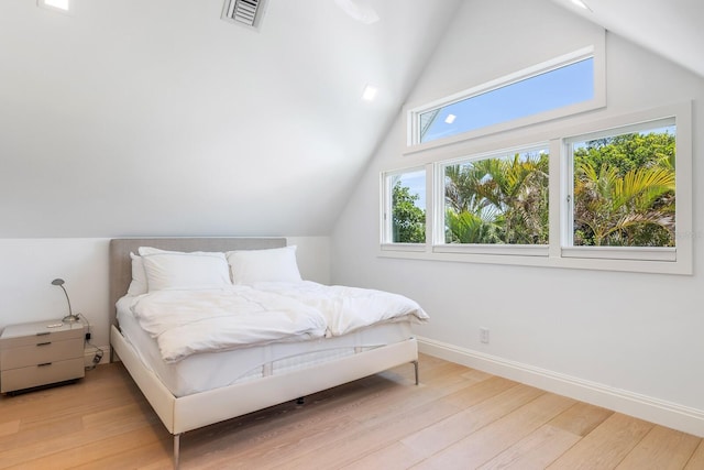 bedroom featuring hardwood / wood-style floors and lofted ceiling