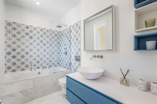 full bathroom with vanity, tiled shower / bath combo, and toilet