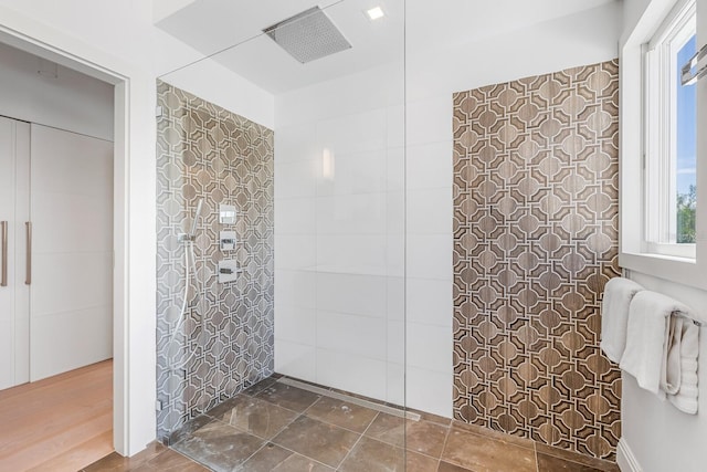 bathroom with a shower, hardwood / wood-style flooring, and tile walls