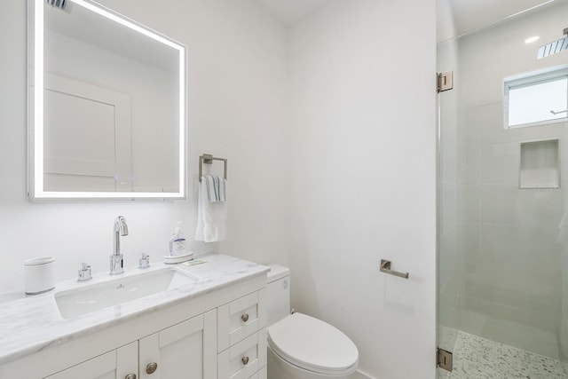 bathroom featuring vanity, toilet, and a shower with shower door