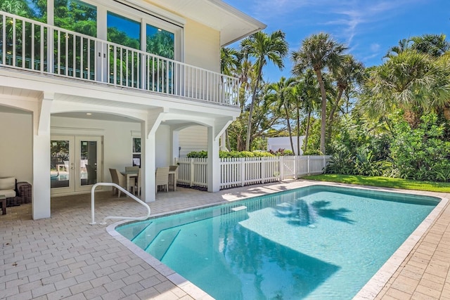 view of swimming pool with french doors and a patio area