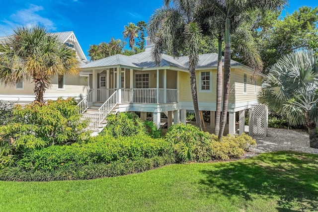 view of front facade with a front yard, a porch, and a carport