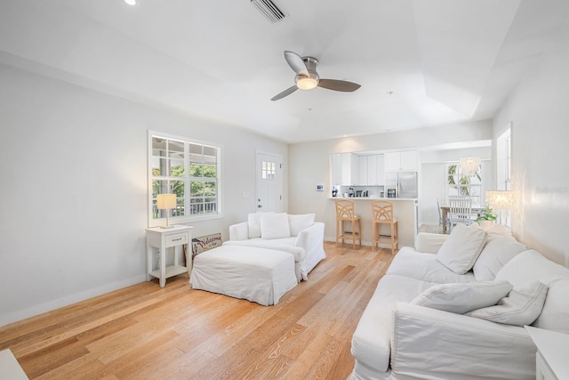 living room with ceiling fan and light hardwood / wood-style flooring