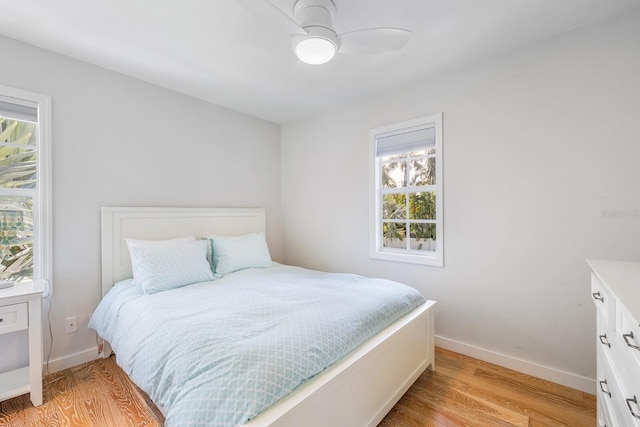 bedroom featuring multiple windows, ceiling fan, and light hardwood / wood-style flooring