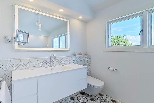 bathroom featuring tile patterned floors, vanity, a healthy amount of sunlight, and toilet