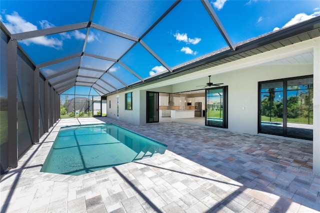 view of swimming pool with a lanai, ceiling fan, and a patio