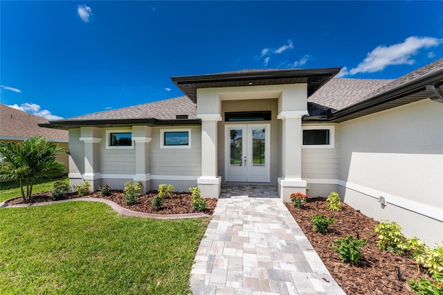 entrance to property with a yard and french doors