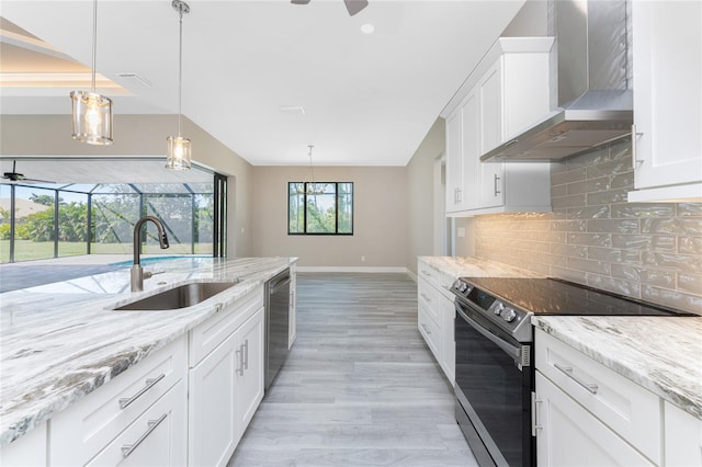 kitchen with light wood-type flooring, sink, wall chimney range hood, electric range, and white cabinets