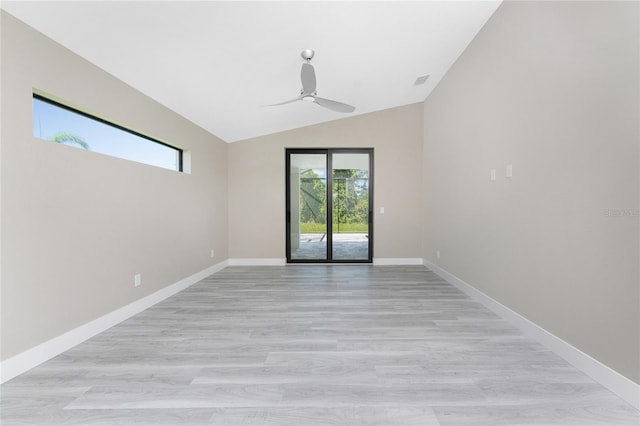 empty room featuring ceiling fan, vaulted ceiling, and light wood-type flooring