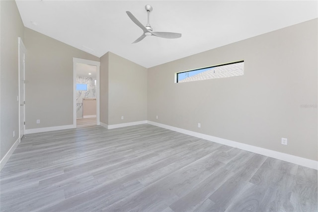 empty room featuring ceiling fan, lofted ceiling, and light wood-type flooring