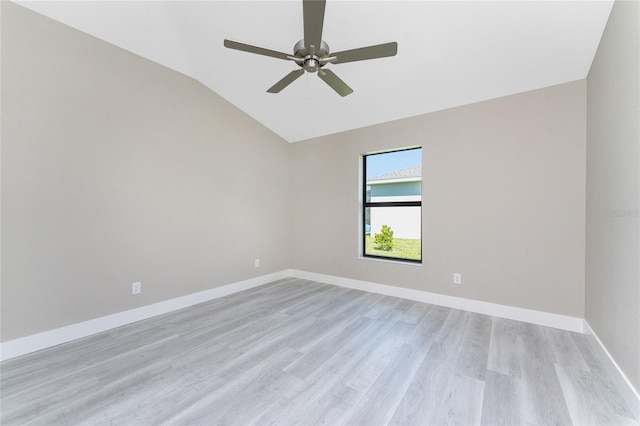 spare room with light hardwood / wood-style flooring, vaulted ceiling, and ceiling fan