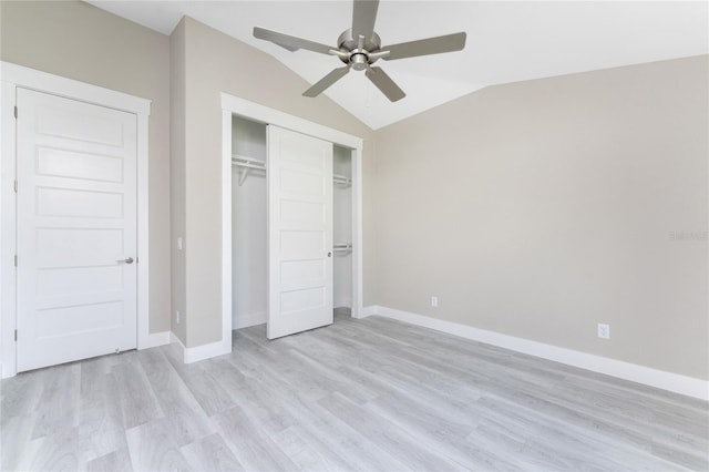 unfurnished bedroom with ceiling fan, a closet, lofted ceiling, and light hardwood / wood-style flooring