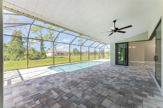 view of swimming pool with ceiling fan, a patio area, a yard, and glass enclosure