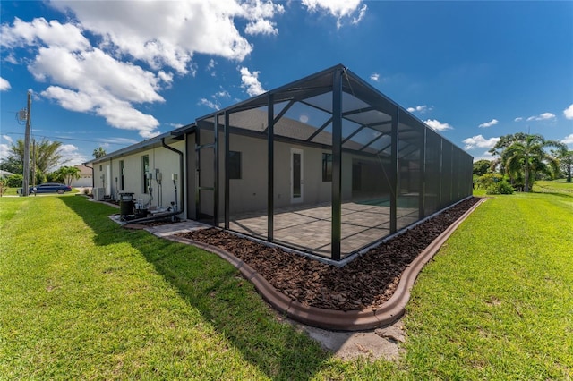 rear view of property with a lawn, a patio area, and a lanai