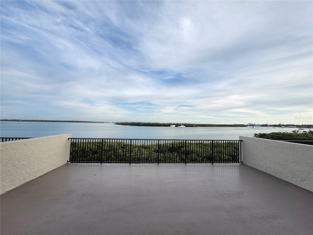 view of patio with a balcony and a water view