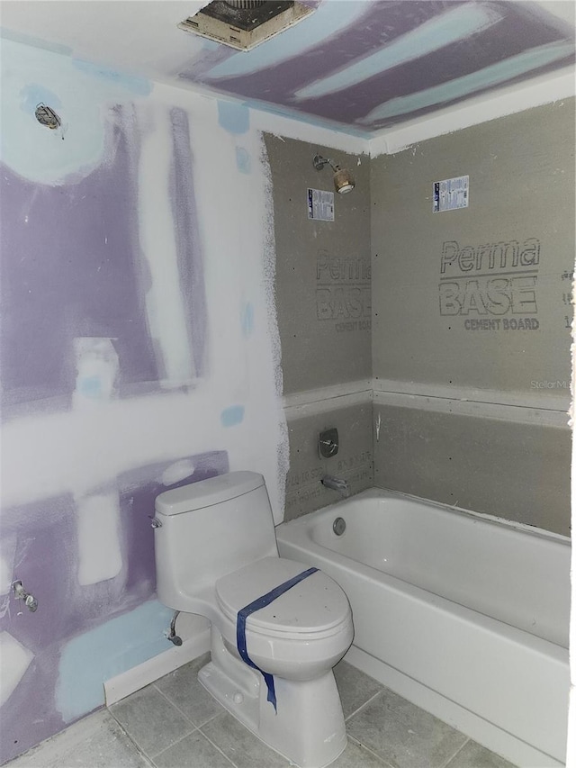 bathroom featuring toilet, tile patterned floors, and a bathing tub