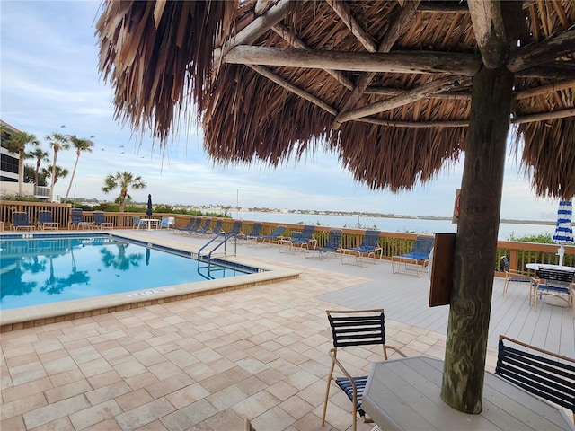 view of swimming pool featuring a patio area and a water view