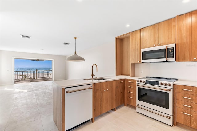 kitchen featuring white appliances, light countertops, a sink, and a peninsula