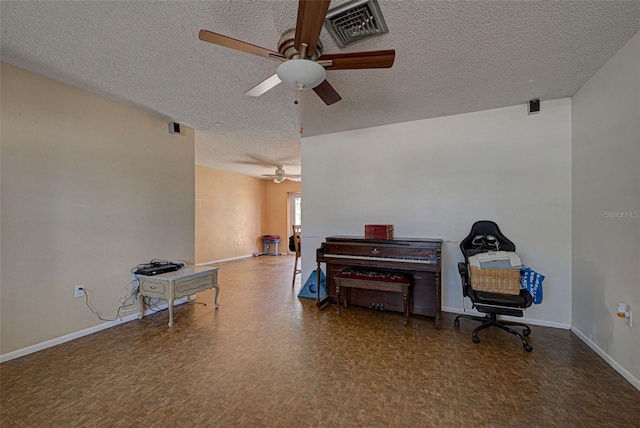 miscellaneous room with a textured ceiling and ceiling fan