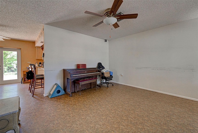 misc room featuring ceiling fan and a textured ceiling