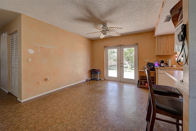 interior space with french doors, a textured ceiling, and ceiling fan