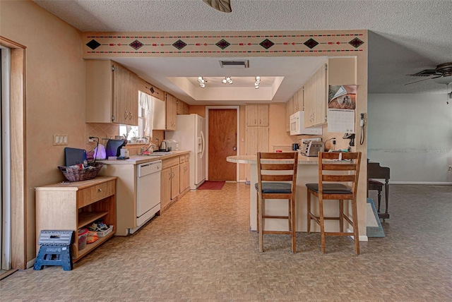 kitchen featuring a textured ceiling, white appliances, a raised ceiling, ceiling fan, and sink