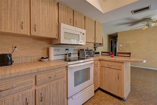 kitchen featuring white appliances, decorative backsplash, ceiling fan, a textured ceiling, and kitchen peninsula