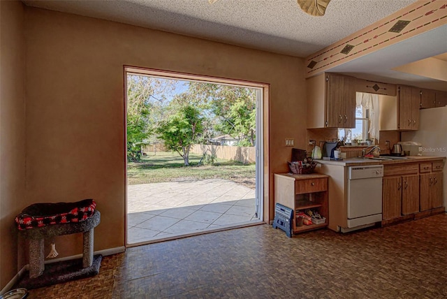 kitchen featuring dishwasher, a textured ceiling, and sink