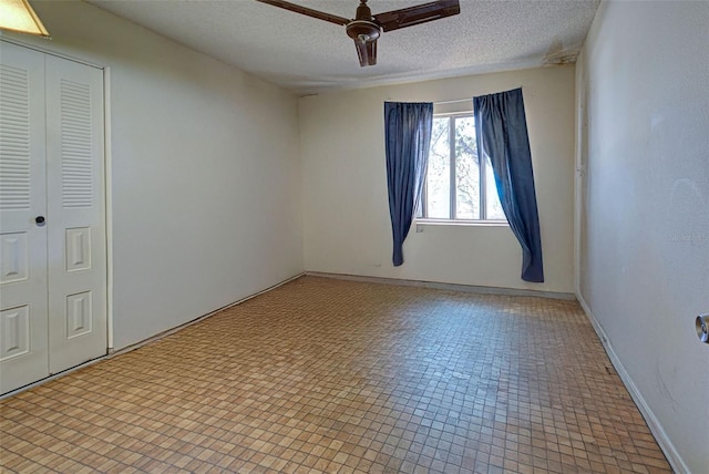 tiled empty room featuring a textured ceiling and ceiling fan