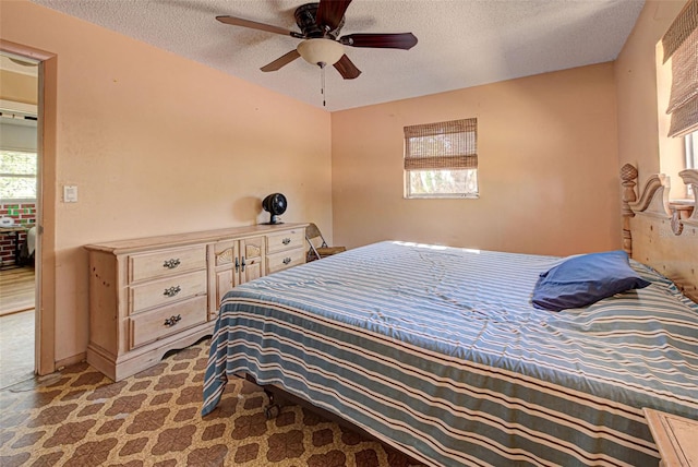 carpeted bedroom featuring ceiling fan and a textured ceiling