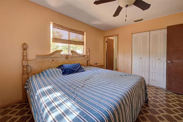 carpeted bedroom featuring ceiling fan, a textured ceiling, and a closet