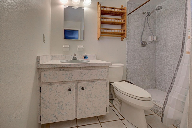 bathroom with tile patterned floors, vanity, walk in shower, and toilet