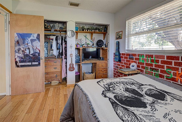 bedroom featuring a closet, a textured ceiling, and light wood-type flooring