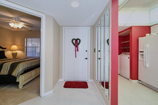 entrance foyer with ceiling fan, light tile patterned flooring, a textured ceiling, and washer / dryer