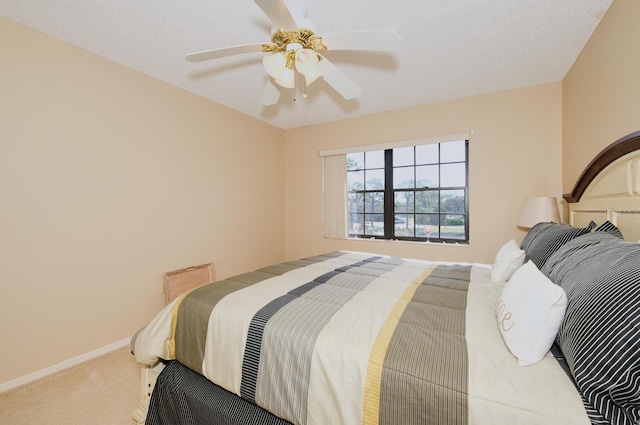 bedroom with ceiling fan, carpet, and a textured ceiling